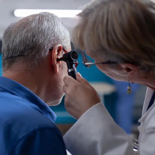 Un ORL regarde l'intérieur de l'oreille d'un patient