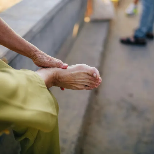 Zoom sur une personne se touchant le pied à cause de la douleur, Groupe Vivalto Santé