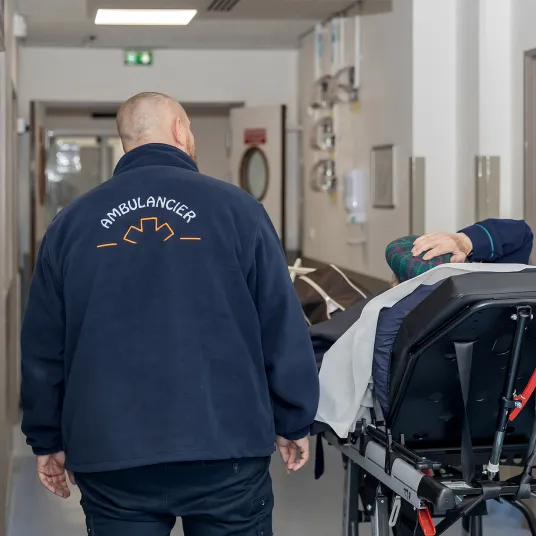 Un ambulancier amène un patient aux urgences