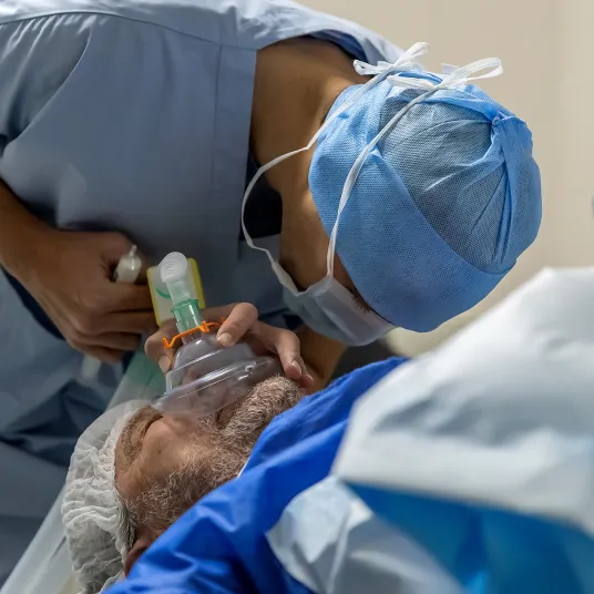 Anesthésiste au bloc opératoire en train d'endormir un patient