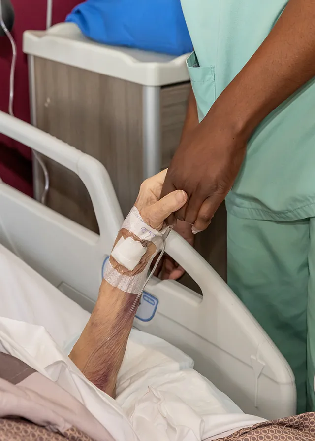 Infirmière et patiente se tiennent la main