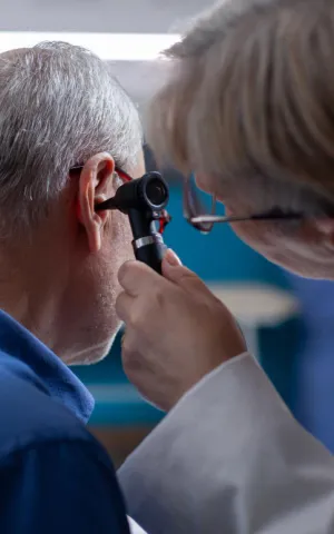 Un ORL regarde l'intérieur de l'oreille d'un patient