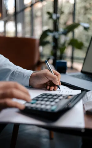 Photo zoomant sur les mains d'un médecin préparant son budget dans le but de s'installer en libéral. 