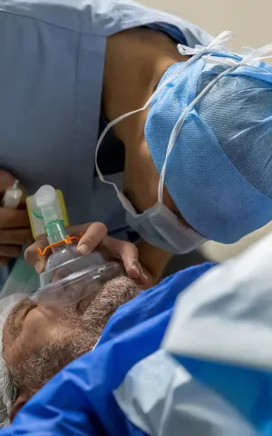Anesthésiste au bloc opératoire en train d'endormir un patient
