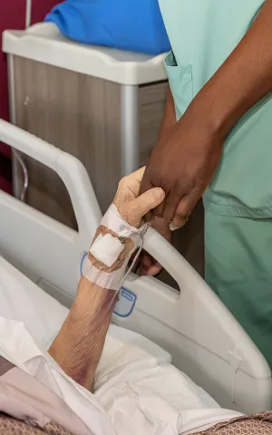 Infirmière et patiente se tiennent la main