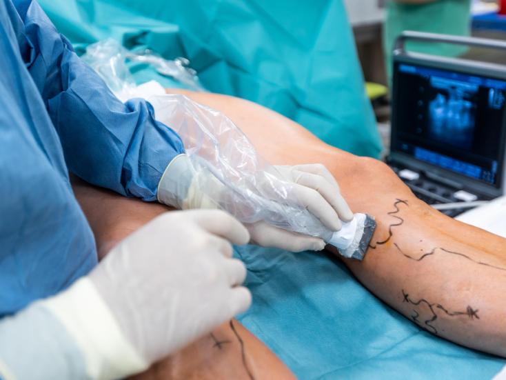 Jambe d'un patient au bloc opératoire avec un chirurgien.
