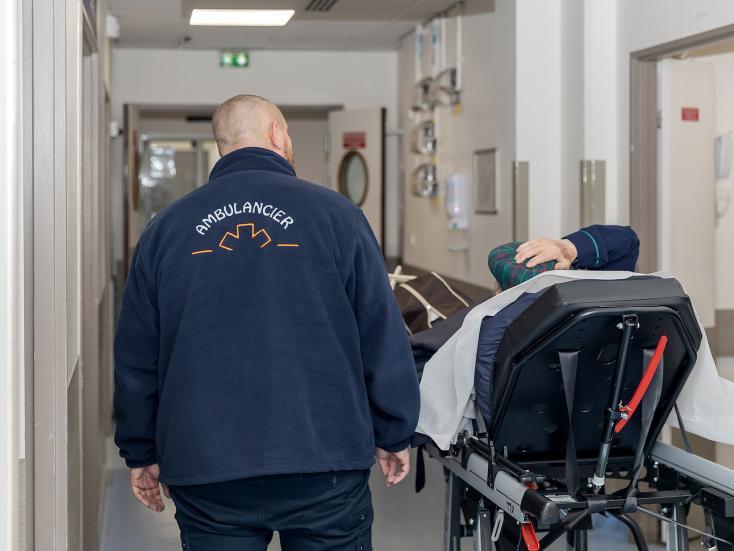 Un ambulancier amène un patient aux urgences