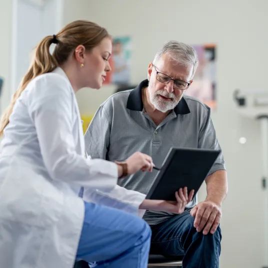 Une femme médecin expliquant au patient sa pathologie en lui montrant une radiologie, Groupe Vivalto Santé.