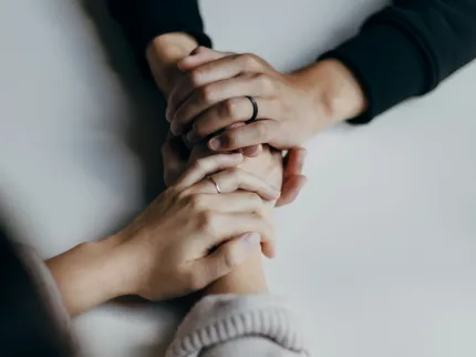 Deux personnes se serrant les mains en signe de compassion et de bienveillance.