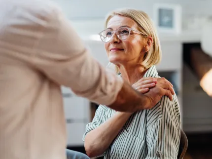 Patient agé souriant au médecin qui lui touche l'épaule en signe d'empathie, Groupe Vivalto Santé