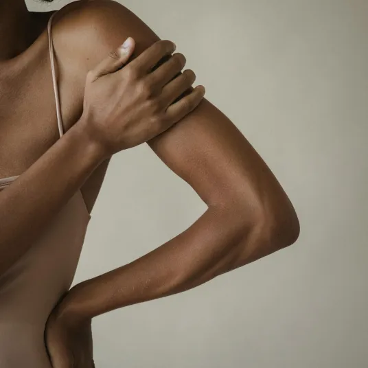 Femme se tenant l'épaule à cause de la douleur - Groupe Vivalto Santé