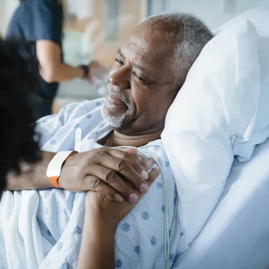 Patient allongé et un proche à ses côtés.