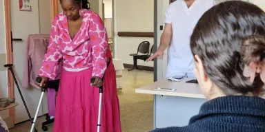 Patiente qui apprend à utiliser des béquilles avec un kiné derrière elle