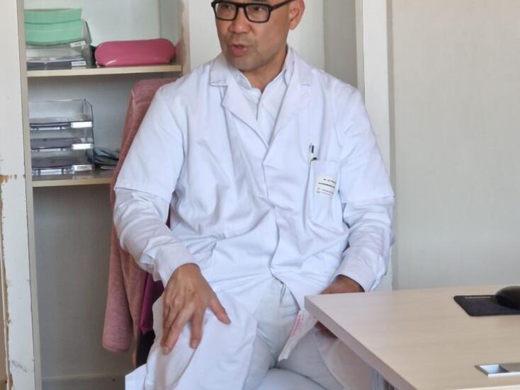 Le Dr Le Thai, chirurgien orthopédique, montre aux patients sa jambe