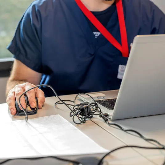 Personnel soignant de la Clinique du Sport Bordeaux-Mérignac derrière un ordinateur.