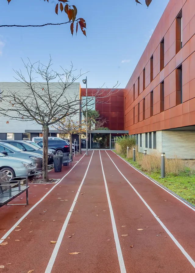 Photo du bâtiment de la Clinique du Sport avec la piste d'athlétisme en premier plan 