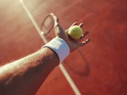 Homme tenant une balle de tennis dans sa main, Clinique du Sport Bordeaux Mérignac