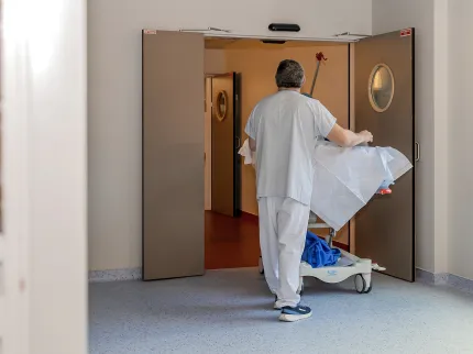 Brancardier poussant un patient sur un brancard dans les couloirs de la Clinique du Sport à Bordeaux Mérignac