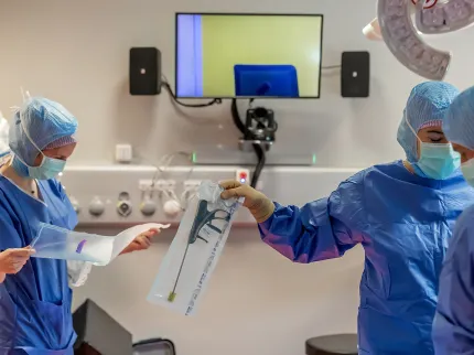 Photo de soignants en salle d'intervention se faisant passer un instrument