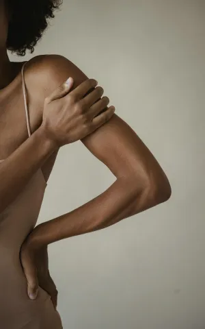 Femme se tenant l'épaule à cause de la douleur - Groupe Vivalto Santé