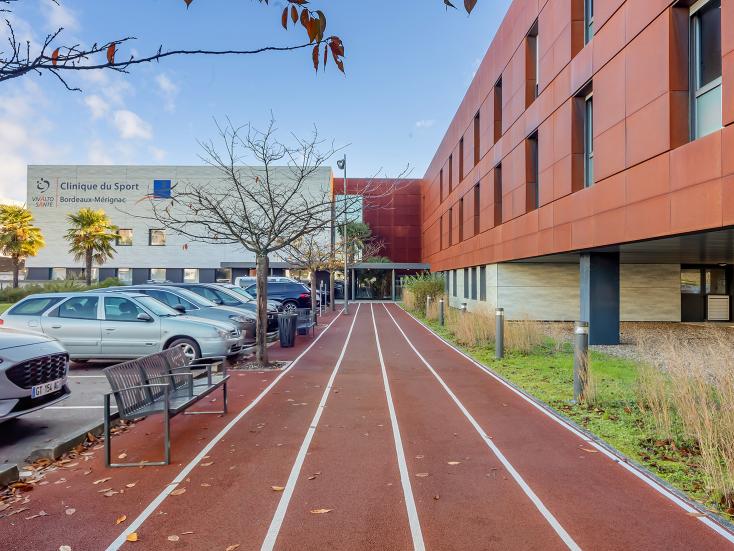 Photo du bâtiment de la Clinique du Sport avec la piste d'athlétisme en premier plan 
