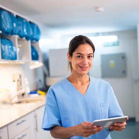 Une infirmière souriant avec une tablette dans les mains, Groupe Vivalto Santé