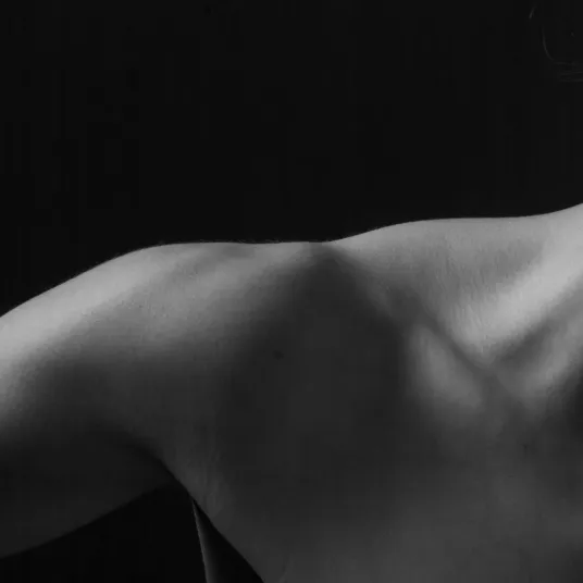 Zoom sur l'épaule d'une femme en noir et blanc, groupe Vivalto Santé