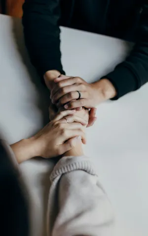 Deux personnes se serrant les mains en signe de compassion et de bienveillance.