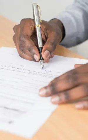 Photo zoomant sur les mains d'un médecin finalisant les formalités administrative de son installation en libéral. 