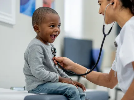 Infirmière s'occupant d'un enfant en lui souriant