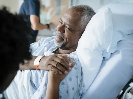 Patient allongé et un proche à ses côtés.