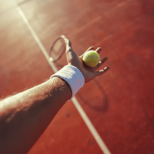 Homme tenant une balle de tennis dans sa main, Clinique du Sport Bordeaux Mérignac