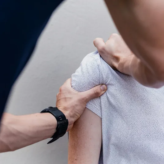 Personne qui ausculte un épaule