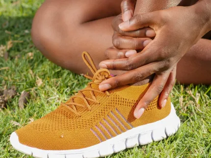 Personne se tenant la cheville à cause de la douleur, Clinique du Sport Bordeaux Mérignac