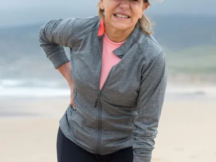 Personne qui se tient la hanche en grimaçant