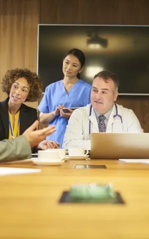 Groupe de médecin actionnaire réunis autour d'une table et discutant de projets médicaux communs, moteurs de développement au bénéfice des patients. C'est la troisième voie du Groupe Vivalto Santé.
