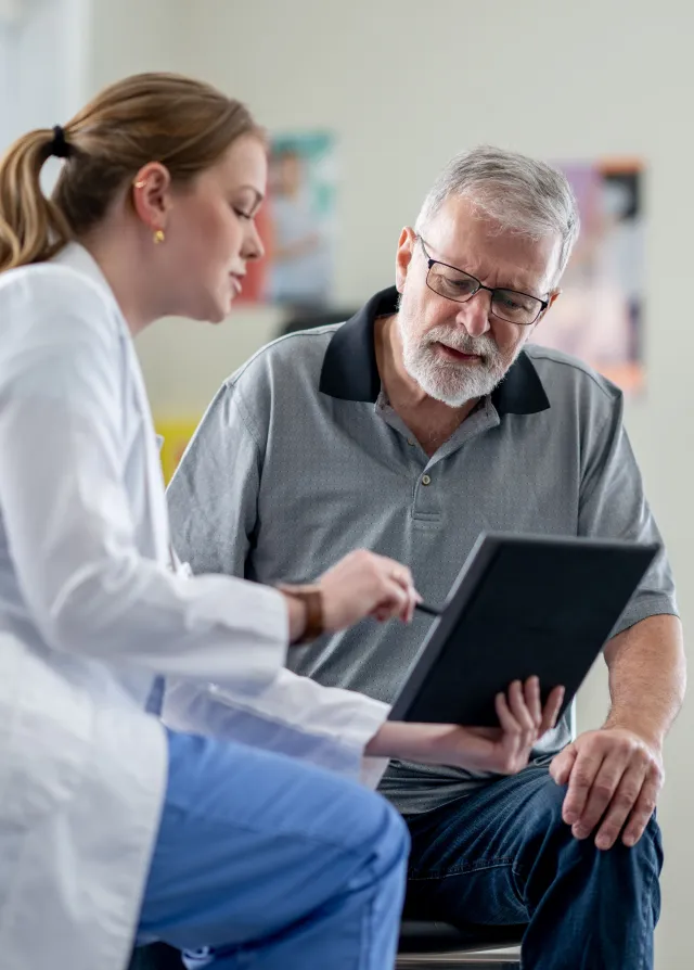 Une femme médecin expliquant au patient sa pathologie en lui montrant une radiologie, Groupe Vivalto Santé.
