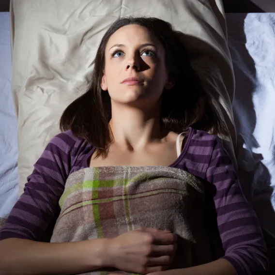 Femme dans son lit avec les yeux ouverts