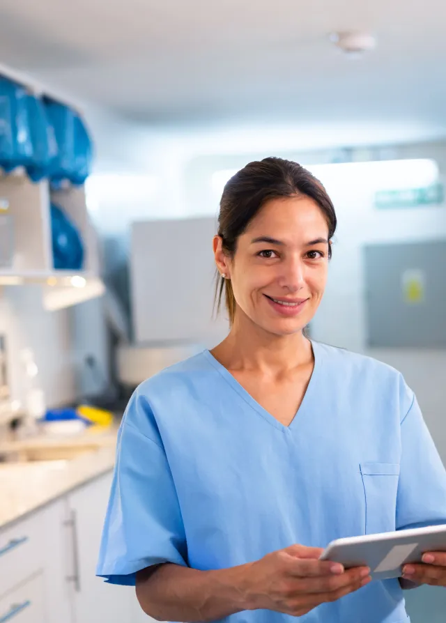Une infirmière souriant avec une tablette dans les mains, Groupe Vivalto Santé