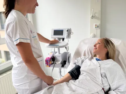 Patiente avec infirmière qui prend sa tension au sein du service ambulatoire