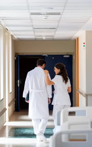 Un médecin et une infirmière marchant dans un couloir. Groupe Vivalto Santé