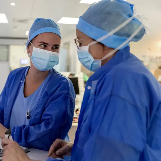 Deux infirmières de bloc opératoire partagent un moment de complicité, les yeux dan les yeux