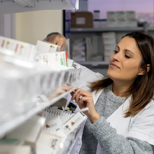 Technicienne de pharmacie prend une boîte de médicament