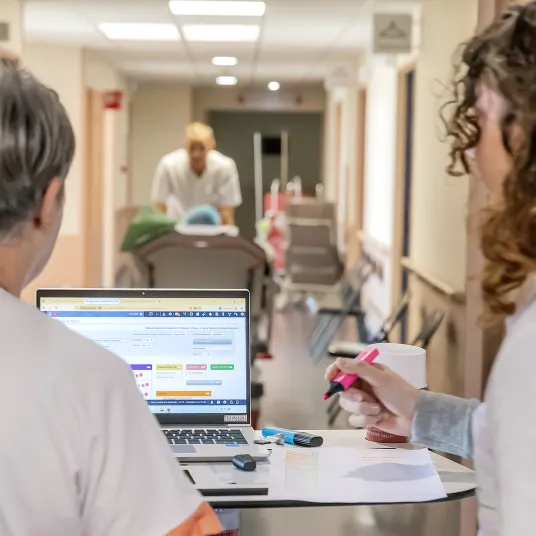 Deux soignants deux dos consultent un dossier de patient