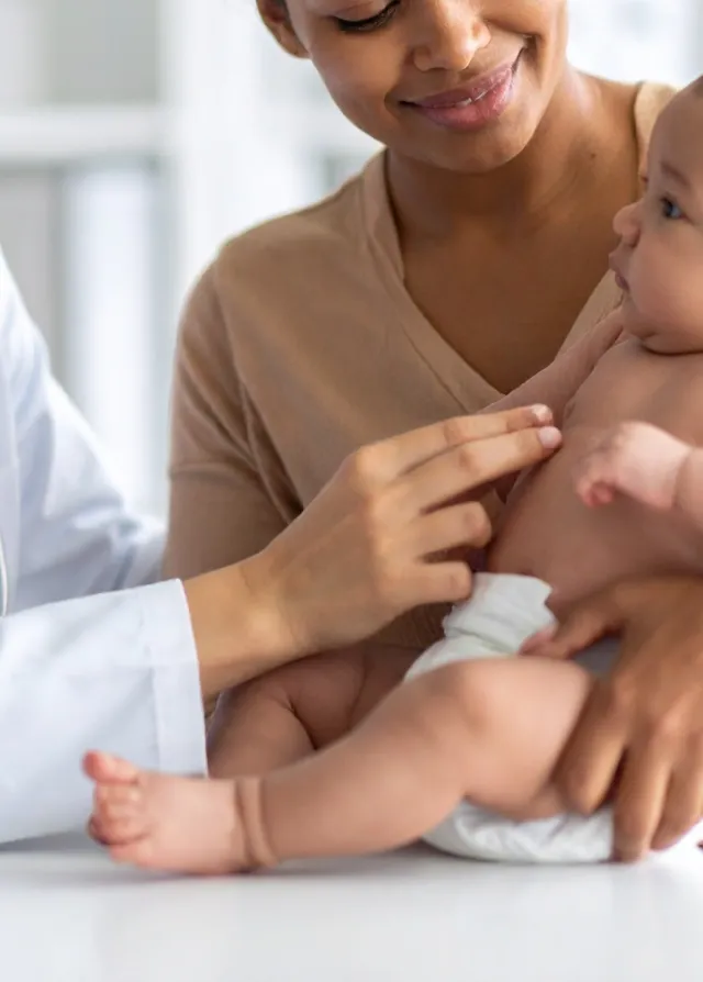Un médecin qui consulte une maman et son nouveau né