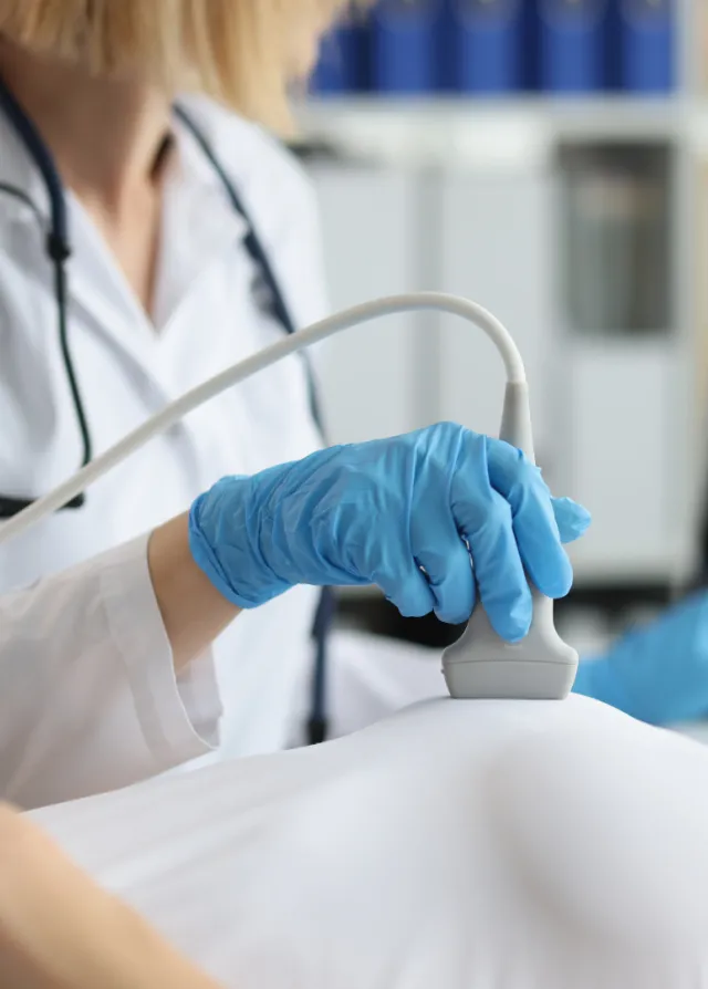 Gynécologue réalisant une échographie mammaire sur une patiente allongée sur sa table d'examen