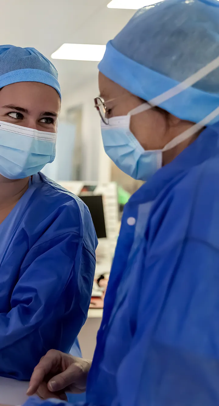 Deux infirmières de bloc opératoire partagent un moment de complicité, les yeux dan les yeux