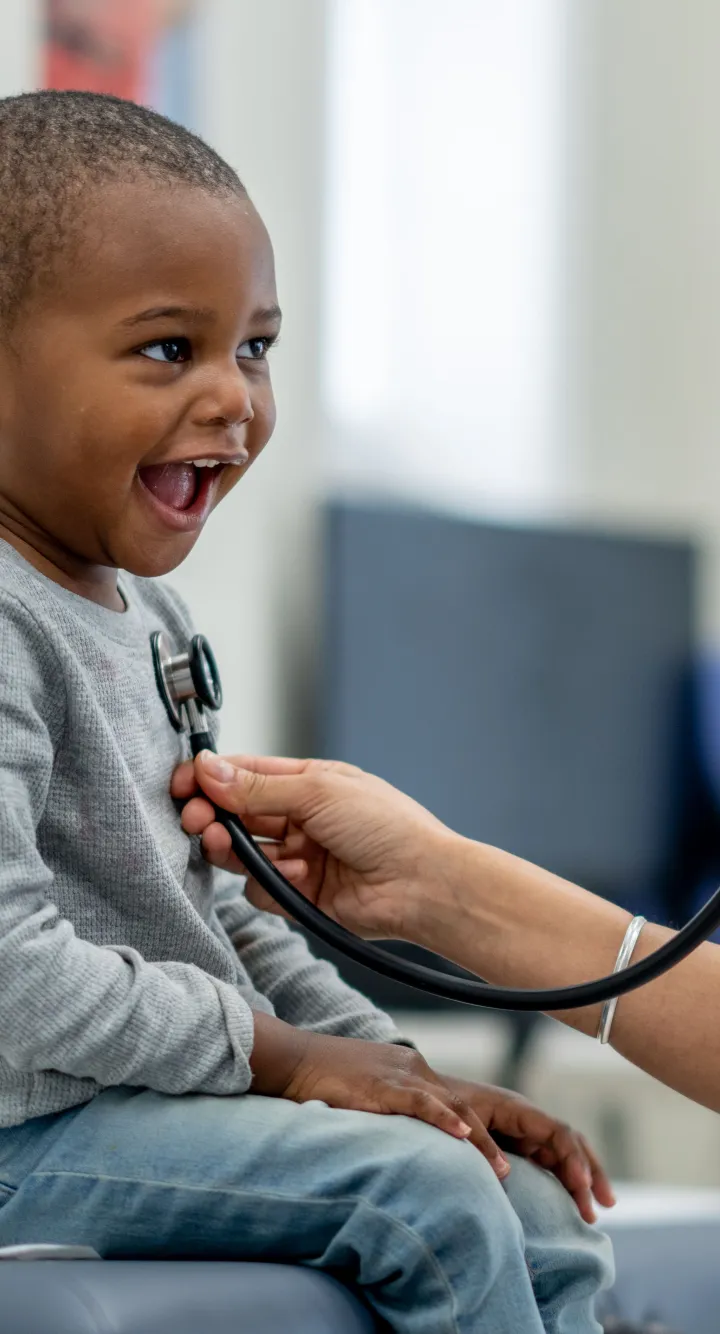 Infirmière s'occupant d'un enfant en lui souriant