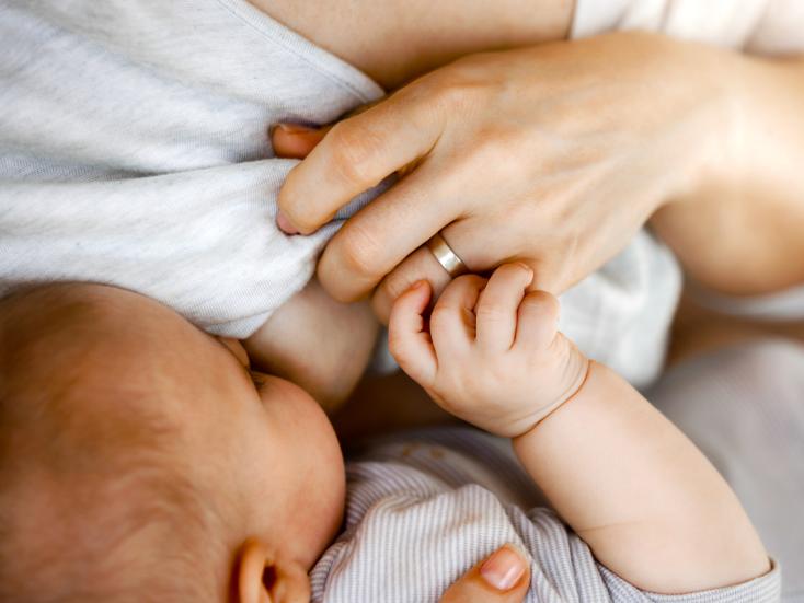 Un bébé tète au sein de sa mère