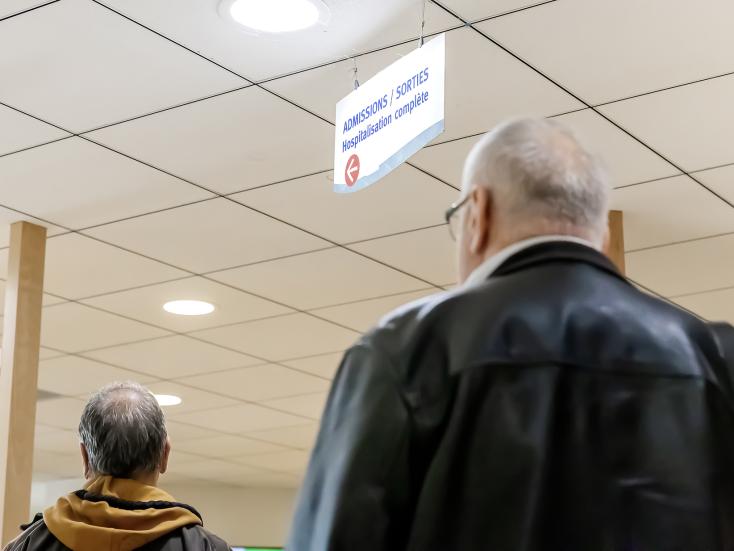 Patient qui suit un panneau indiquant les admissions